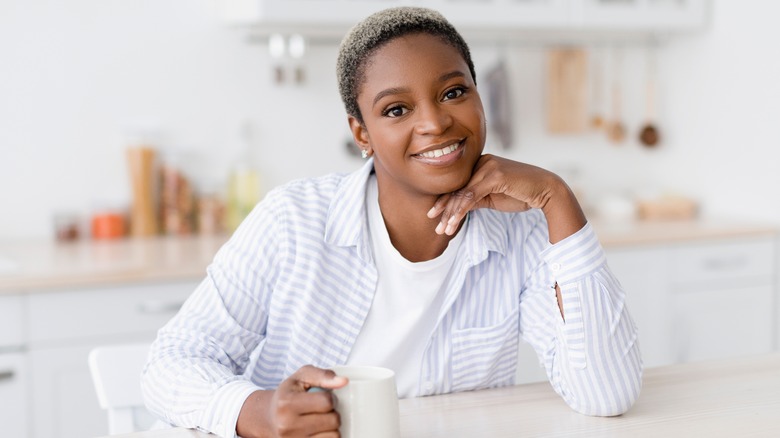 Smiling young woman holding coffee mug