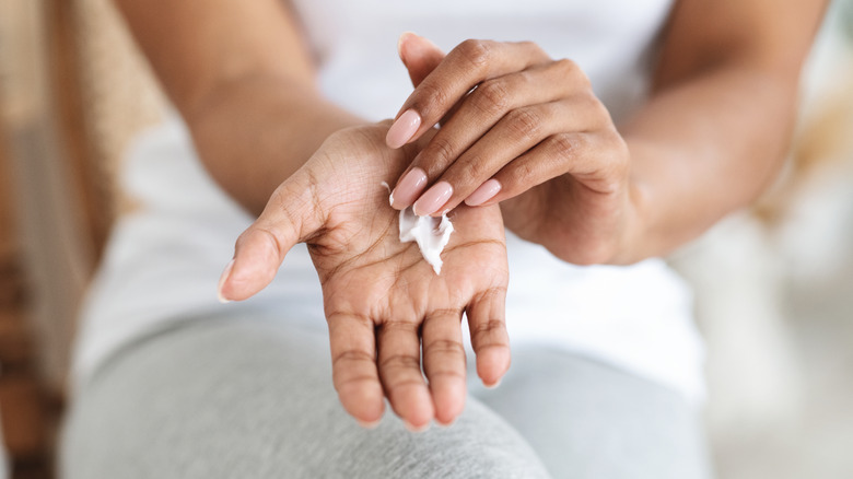 woman using hand lotion