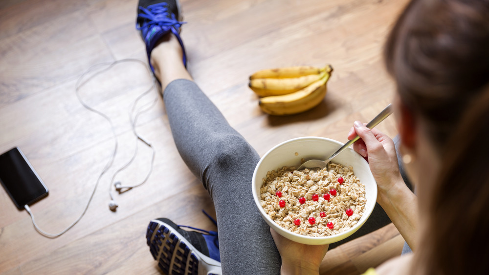woman eating oatmeal with berries post workout 