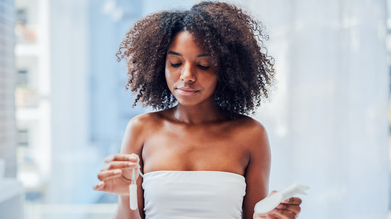 Young woman holding tampon