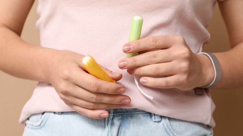 Hands holding two tampons