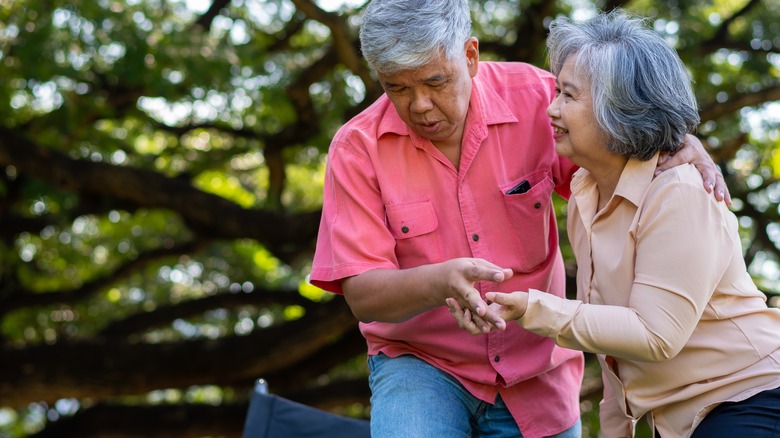 Older couple helping each other keep their balance