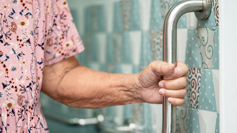 Hand grabbing bathroom safety rail