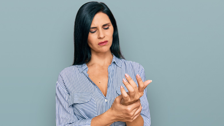 Woman with hand and wrist pain due to arthritis 