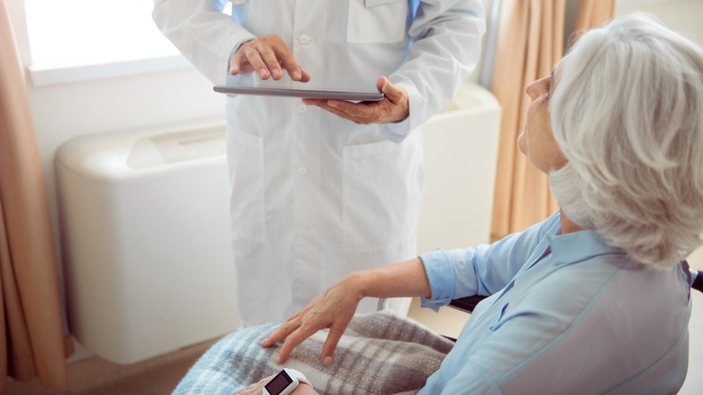 doctor treating woman with smartwatch 