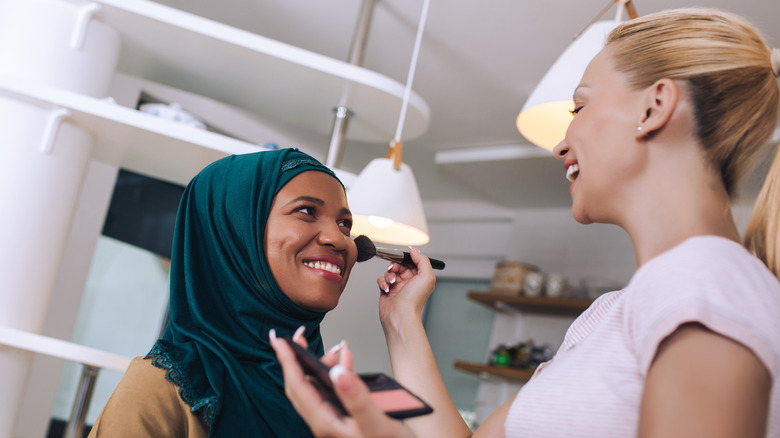 Woman putting makeup on woman