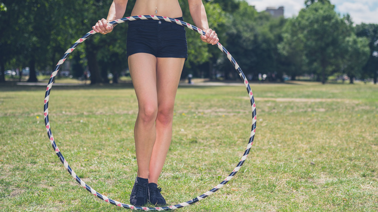 woman holding hula hoop in front of body