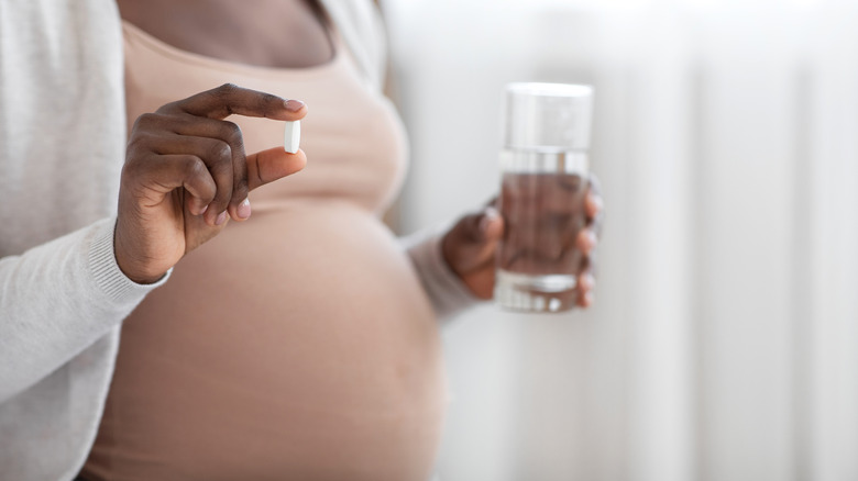 Pregnant woman taking iron supplements to prevent anemia