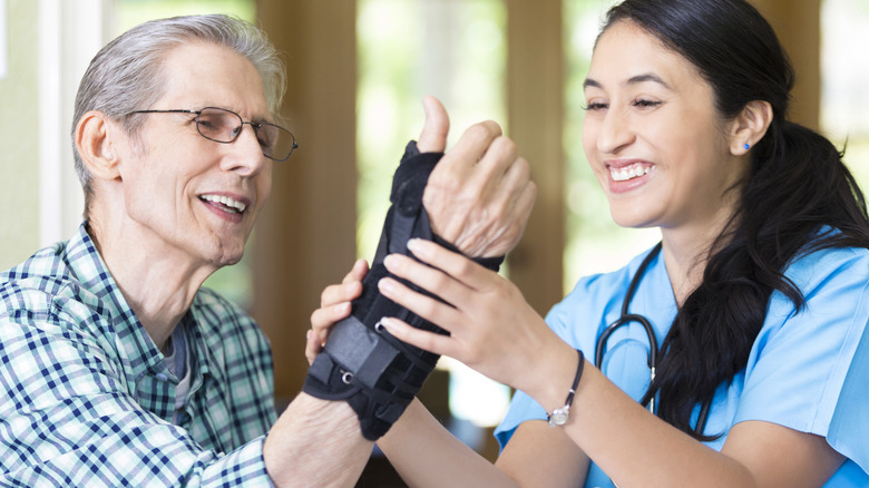 Nurse putting wrist brace on patient