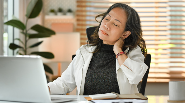 Woman rubbing pain in neck