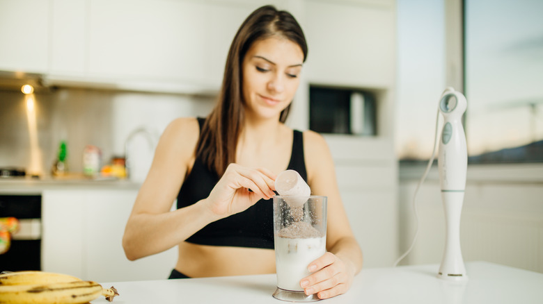 A woman drinks a protein shake