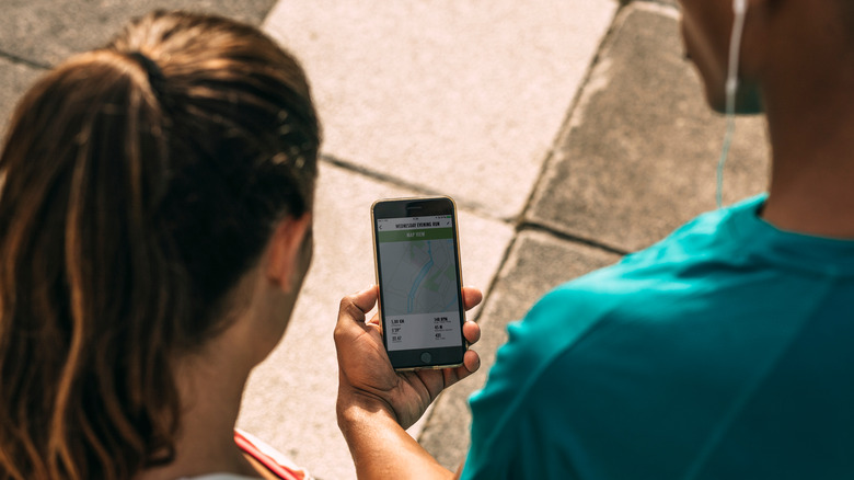 man sharing fitness tracker with woman