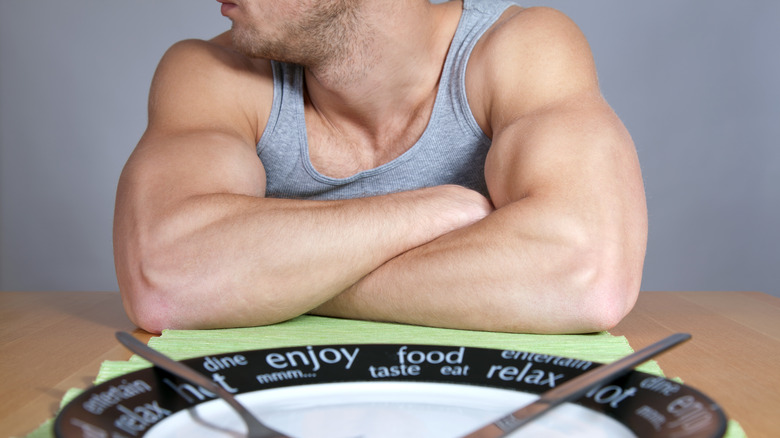 muscular man and empty plate