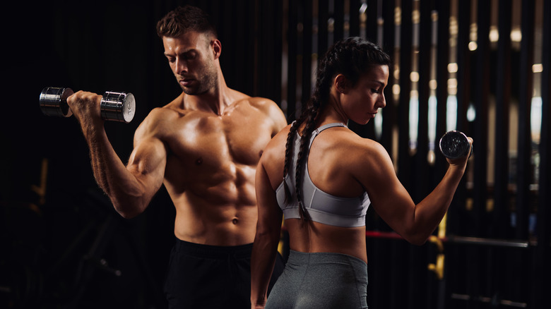 man and woman lifting dumbbells