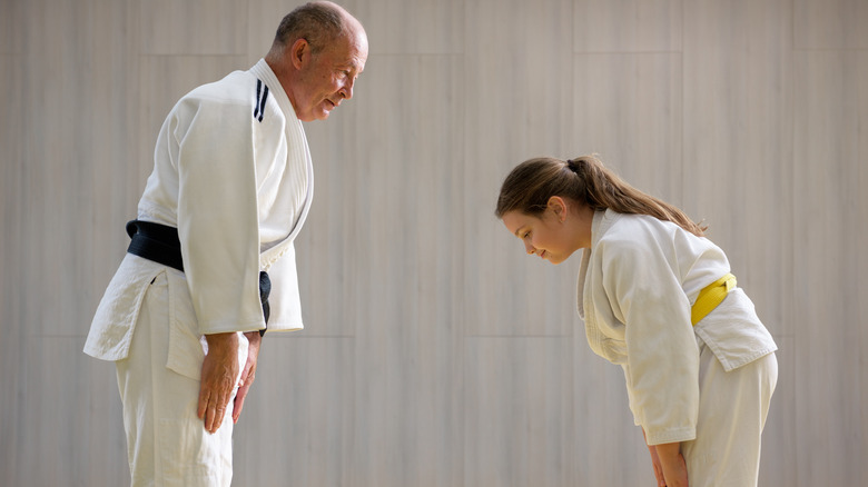 Female judo student showing respect to judo teacher