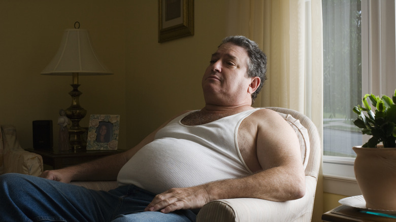 obese middle aged man sitting in chair