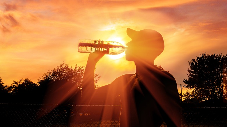 silhouette of man drinking water in extreme heat