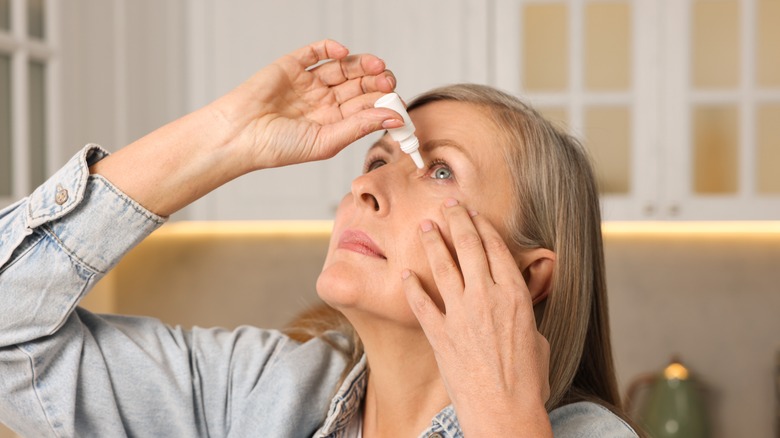 woman putting medicine into her eyes