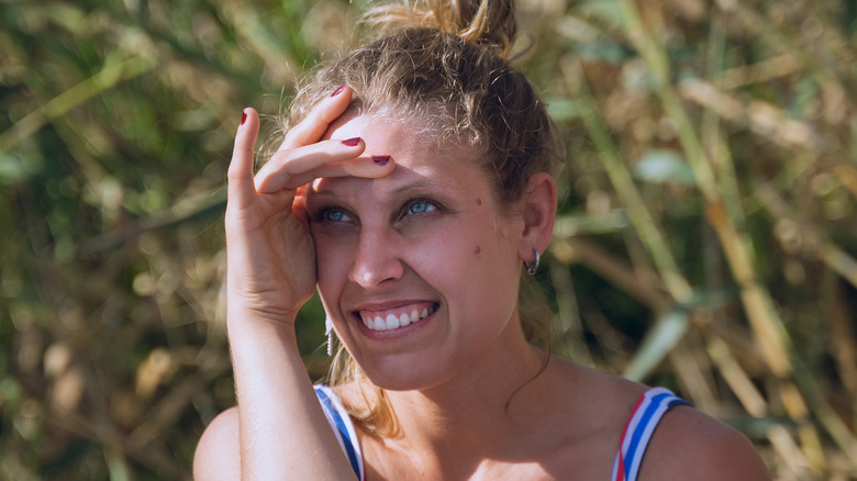 Woman with light eyes squinting in sun