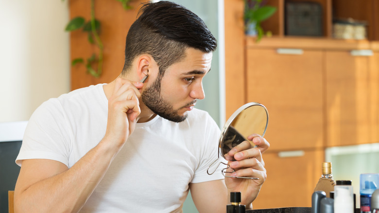 A man plucking ear hairs