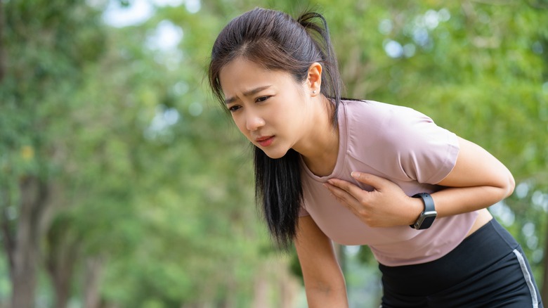 person holding chest during asthma attack