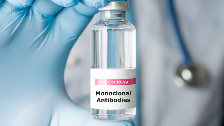 Gloved hand holding a vial of monoclonal antibodies, a new treatment for coronavirus Covid-19