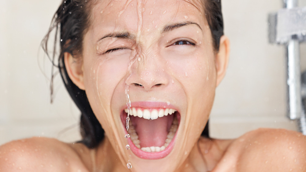 close up of woman taking cold shower