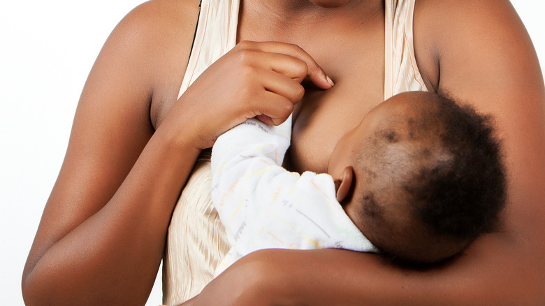 mother carefully breastfeeding child