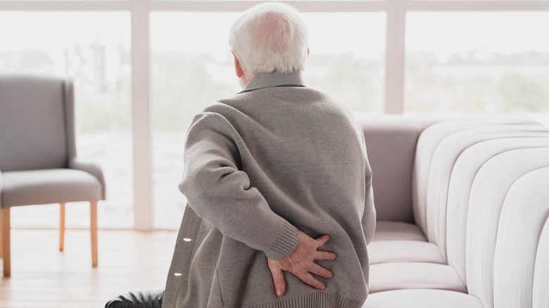 elderly man rubbing back