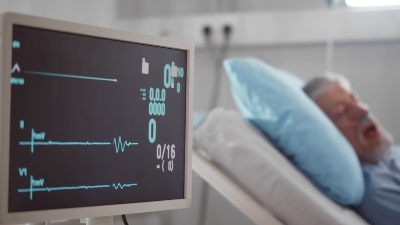 Hospitalized patient next to heart monitor