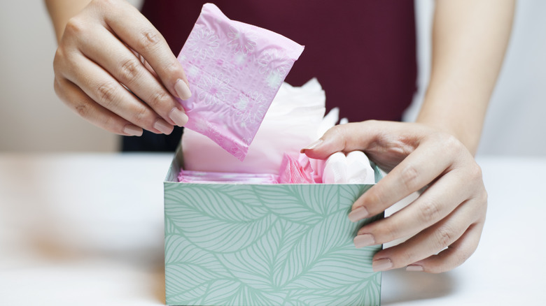 woman grabbing sanitary pad