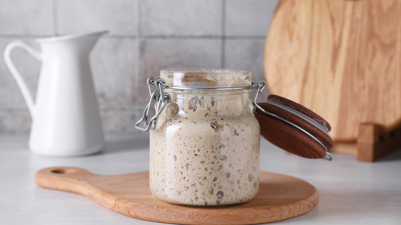 A jar of sourdough starter sitting on a counter