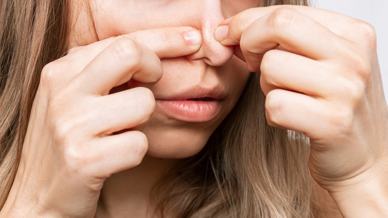 Woman squeezing nose