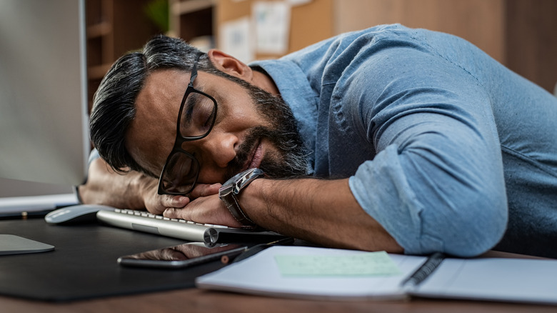 business man at his desk taking a nap 