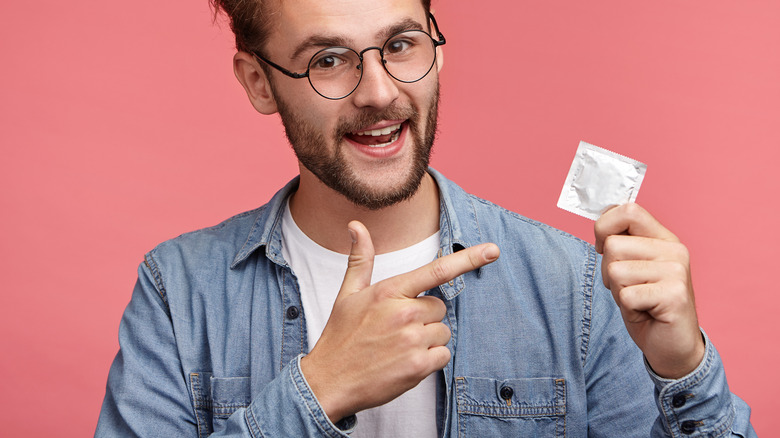 man pointing to condom
