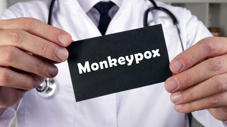 A doctor holds a sign that says monkeypox