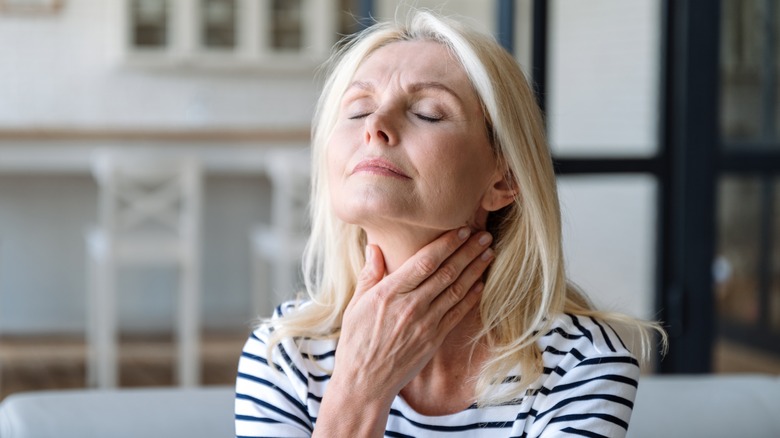 woman touching lymph nodes along neck