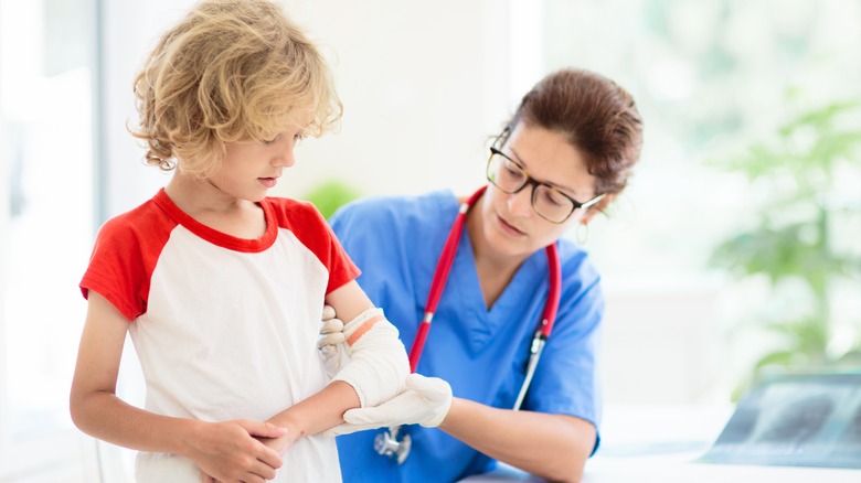 boy with broken elbow tended to by doctor