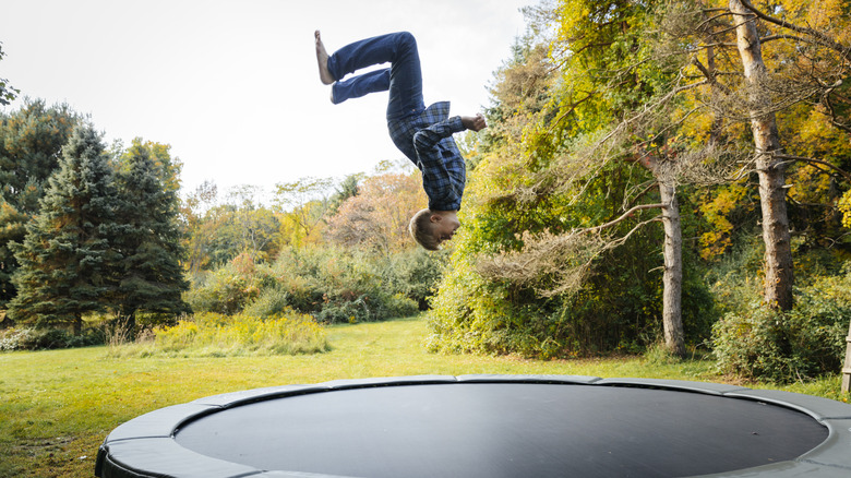 man doing a back flip on a trampoline