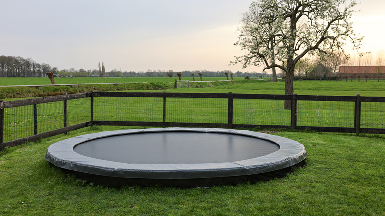 in-ground trampoline surrounded by fence