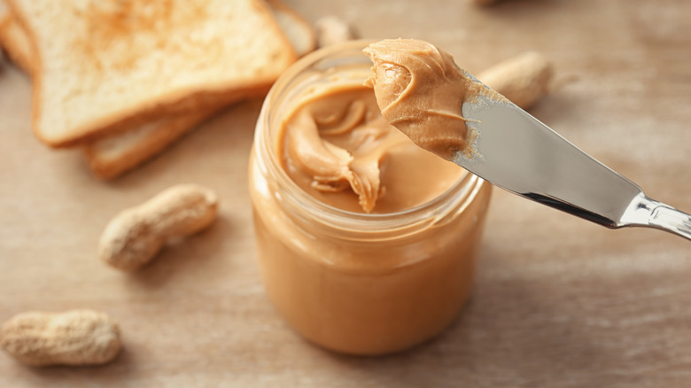 Scoop of peanut butter from jar