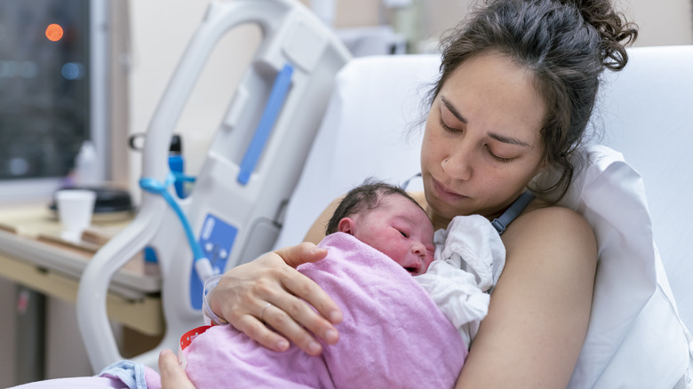 woman kissing her newborn child