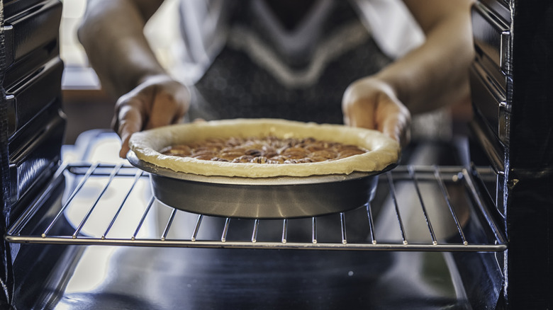 Pulling pie out of oven