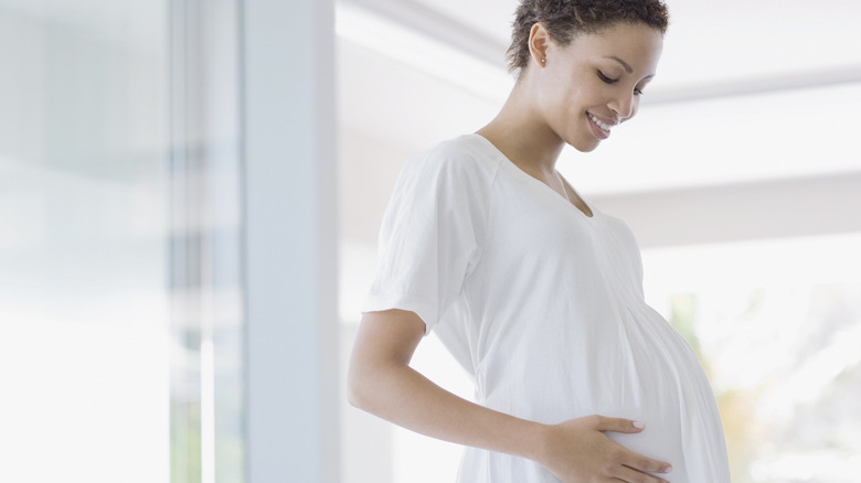 Pregnant woman holding stomach