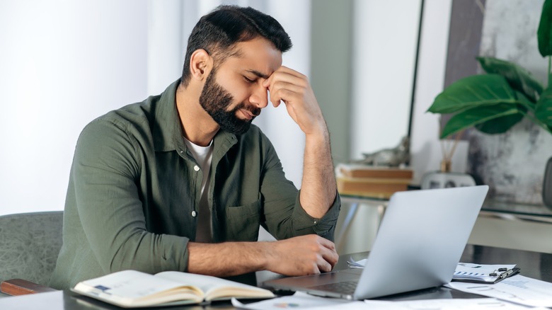 man sitting at desk with a headache