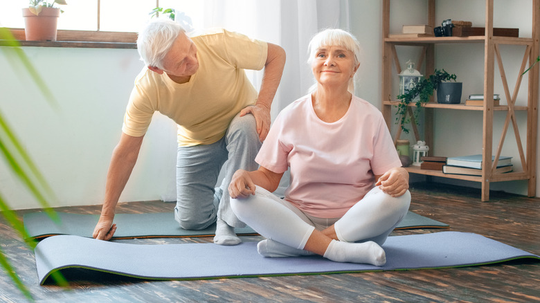 Older couple stretching on mat