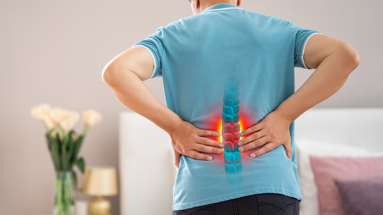 man with hands on lower back and irritated spine