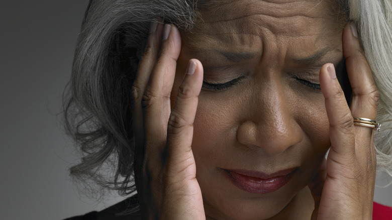 Older woman holding her head in pain