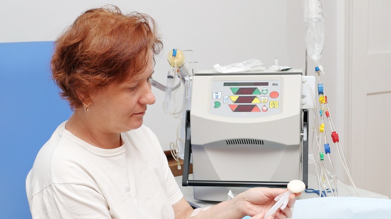 A woman prepares to use a dialysis machine