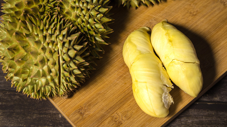 durian flesh lying on a wooden cutting board 